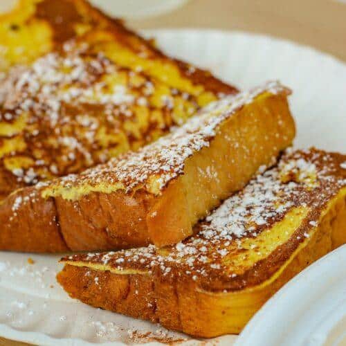 Rabanadas douradas e crocantes polvilhadas com açúcar e canela sobre um prato branco – Receita do Chef Silvio Forech.