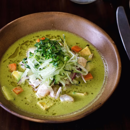 Ceviche verde com leite de tigre de coentro e abacate servido com legumes e cebola crocante