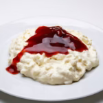 arroz doce cremoso com calda de frutas vermelhas servido em prato branco por chef silvio forech